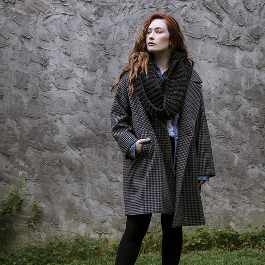 Red haired female wearing a Lucky Tweed donegal merino wool fisherman's rib bulky cowl in 006 black.