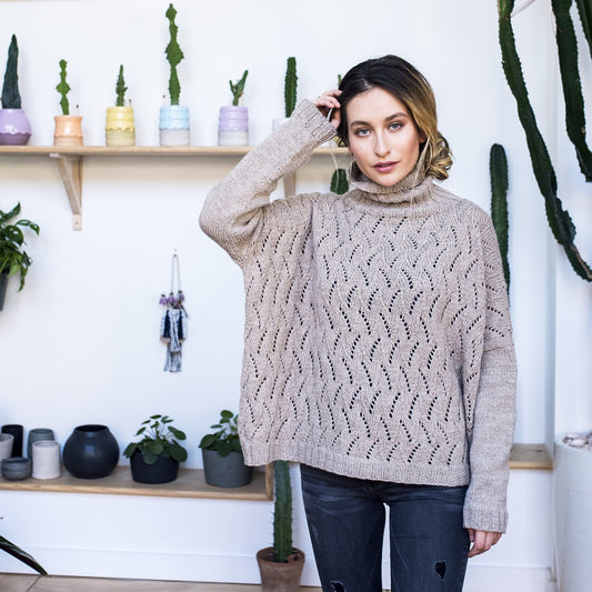 Chinese American female wearing the oversized, lace Sawyer turtleneck sweater in oatmeal heather.
